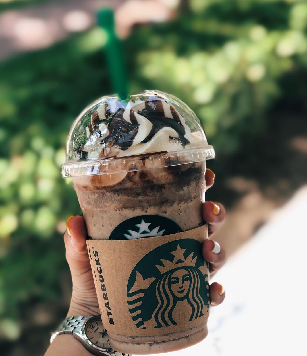 hand holding takeaway cup of starbucks java chip frappucino