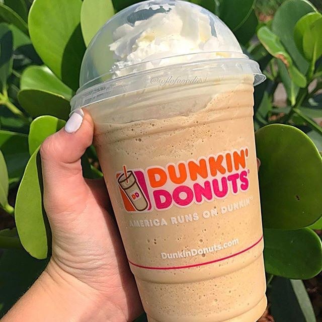 hand showing cup of dunkin donuts frozen coffee or frozen dunkin coffee
