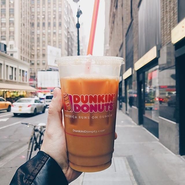 hand showing off dunkin donuts cup of iced coffee