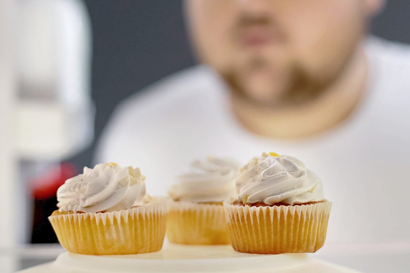 man looks at cupcakes in the fridge