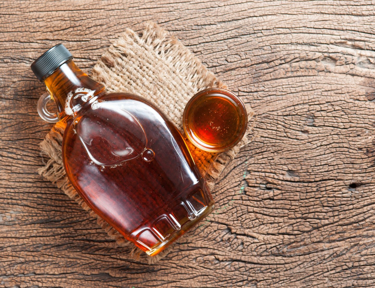 Maple,Syrup,In,Glass,Bottle,On,Wooden,Table