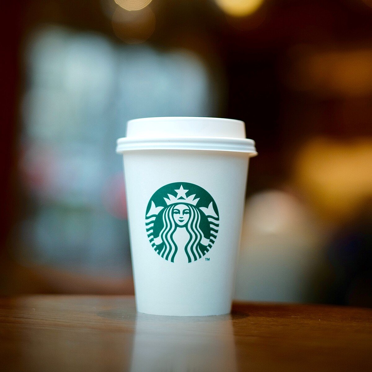 paper cup with starbucks logo on wooden table