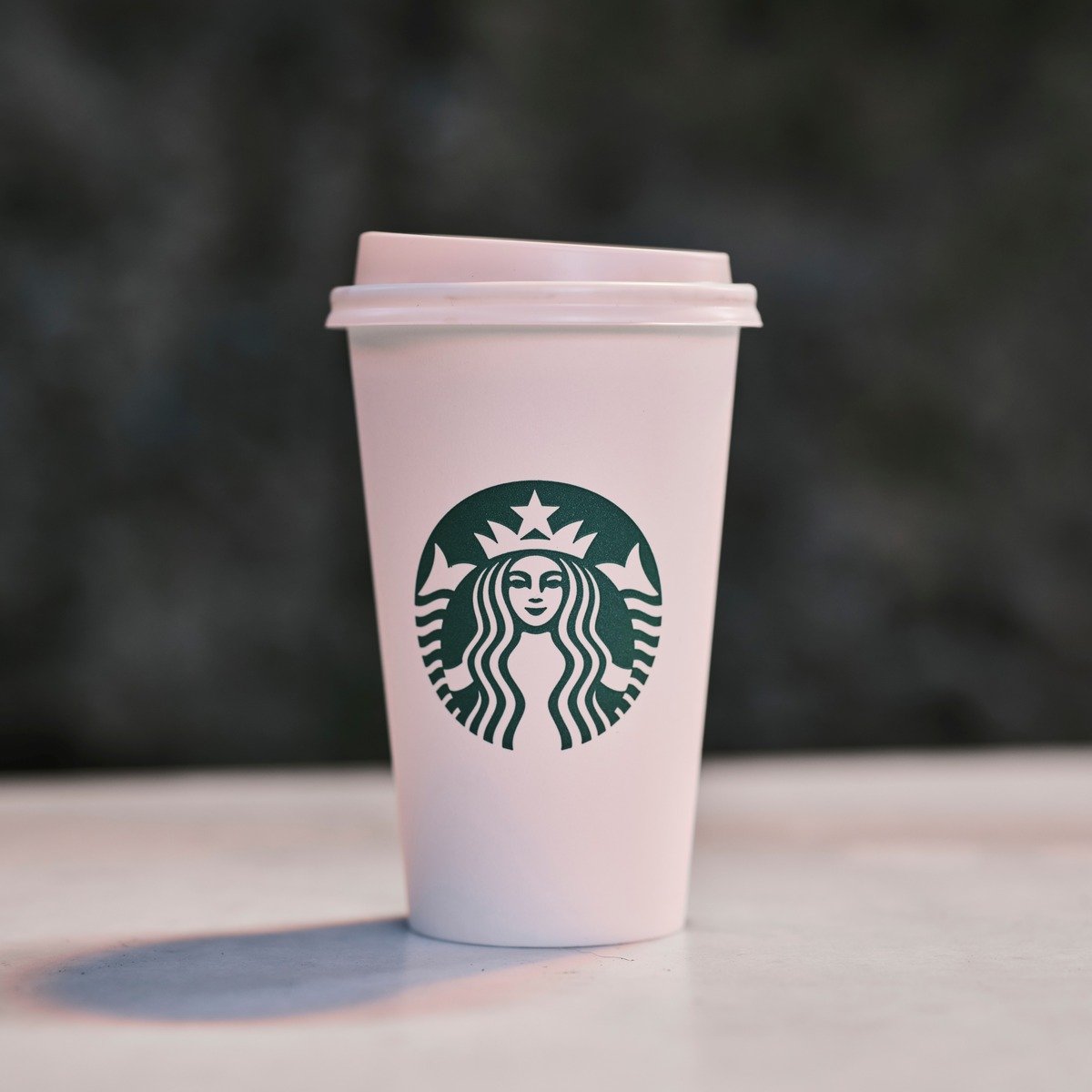 starbucks paper takeaway cup on white surface with shadow