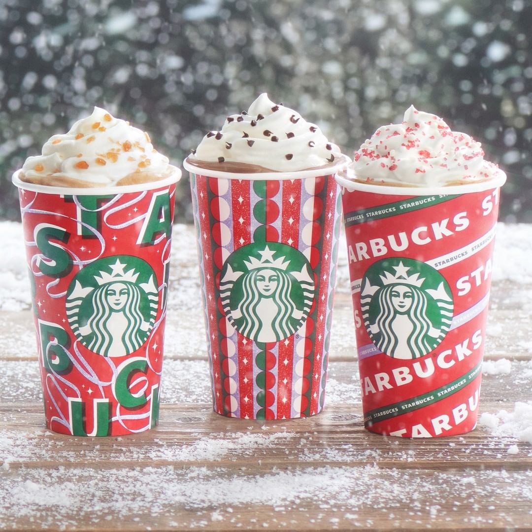 three cups of starbucks frappuccinos on snowy surface