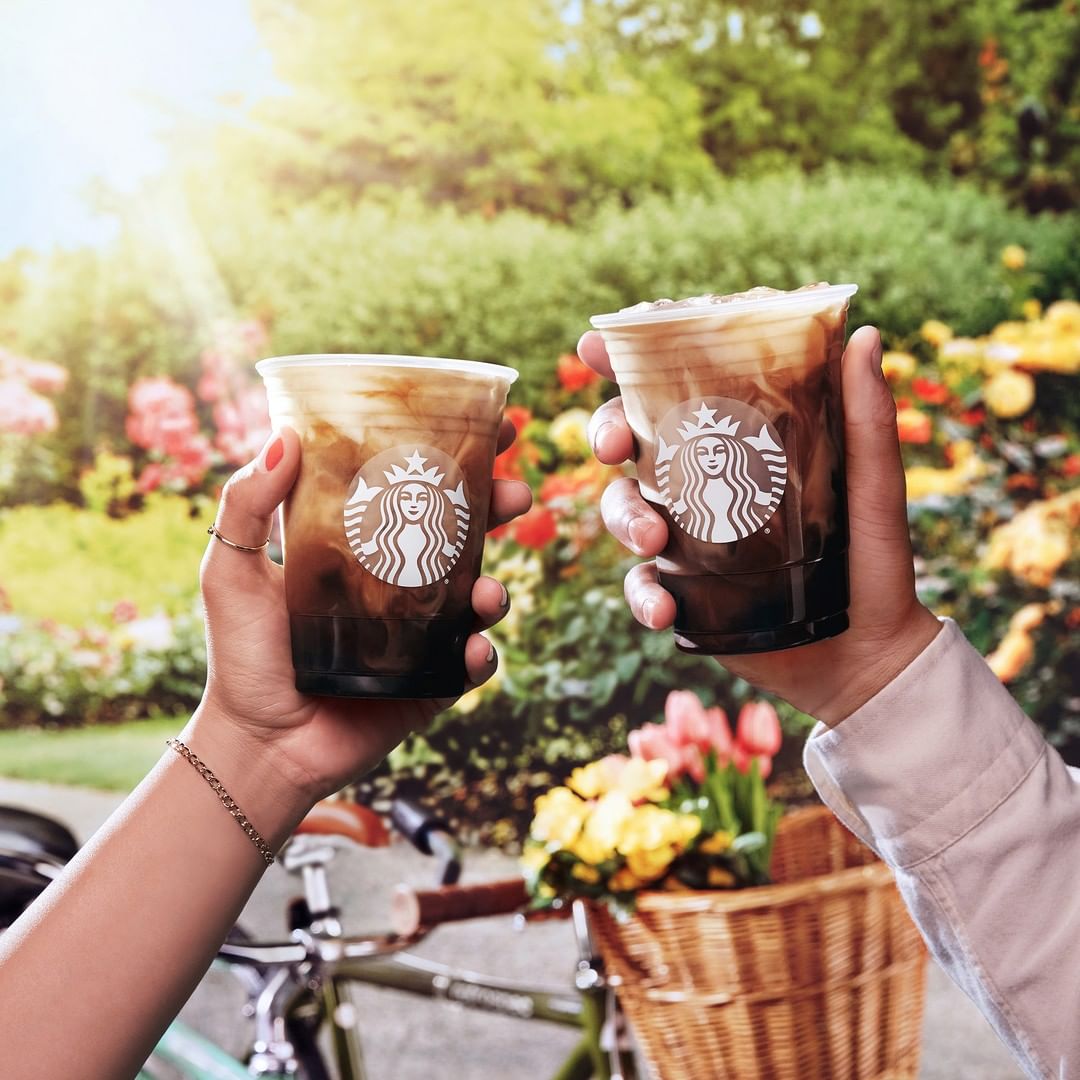 two hands holding cups of starbucks iced shaken espresso