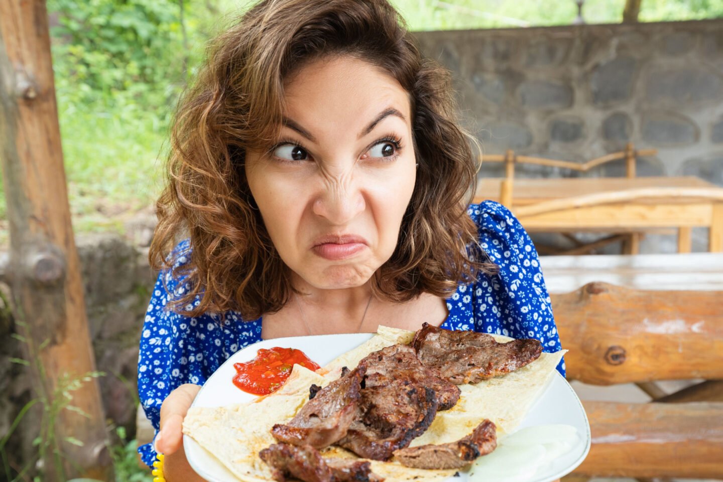 woman holding a plate of spoiled steak