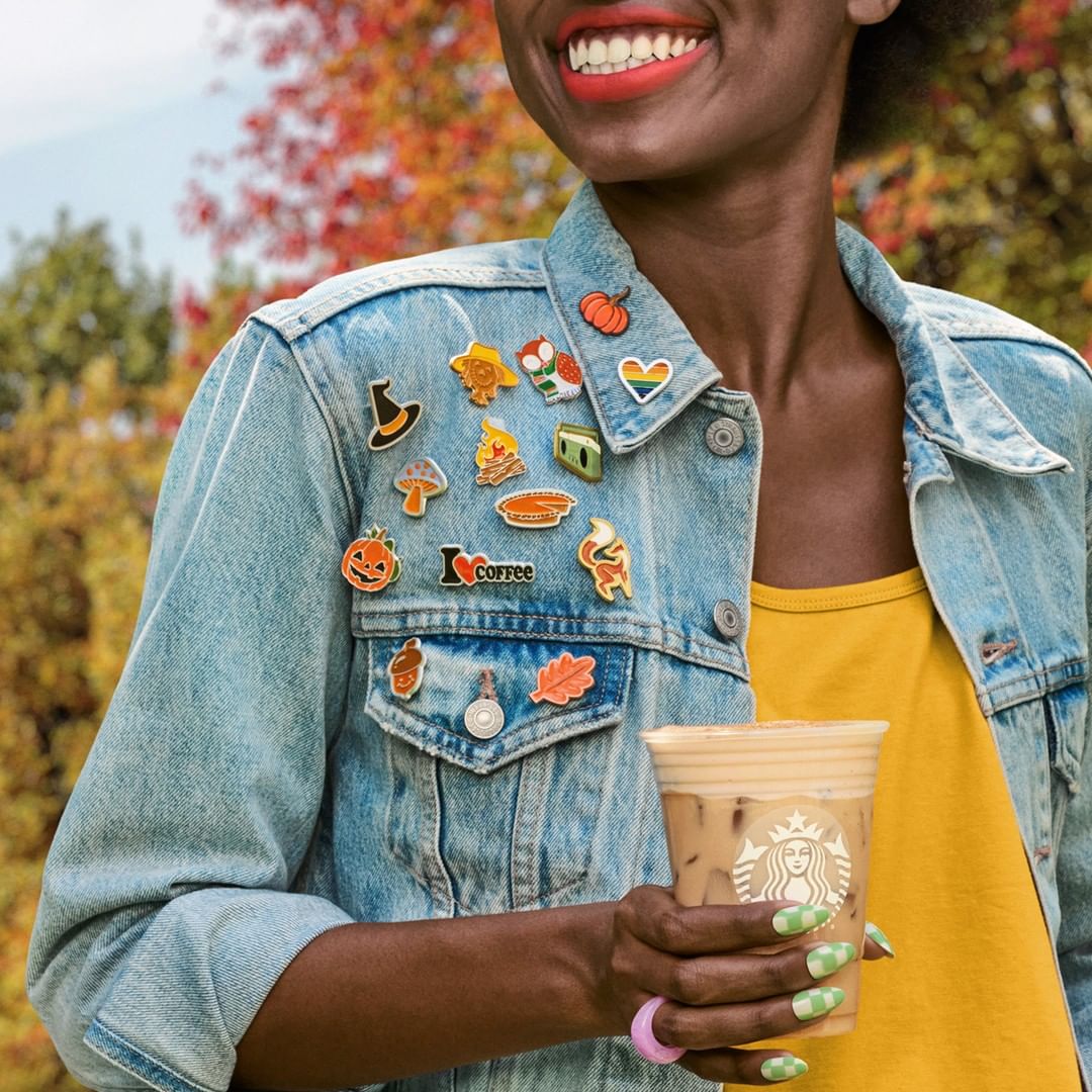 woman holding cup of starbucks iced chai tea latte with pumpkin cream cold foam on top