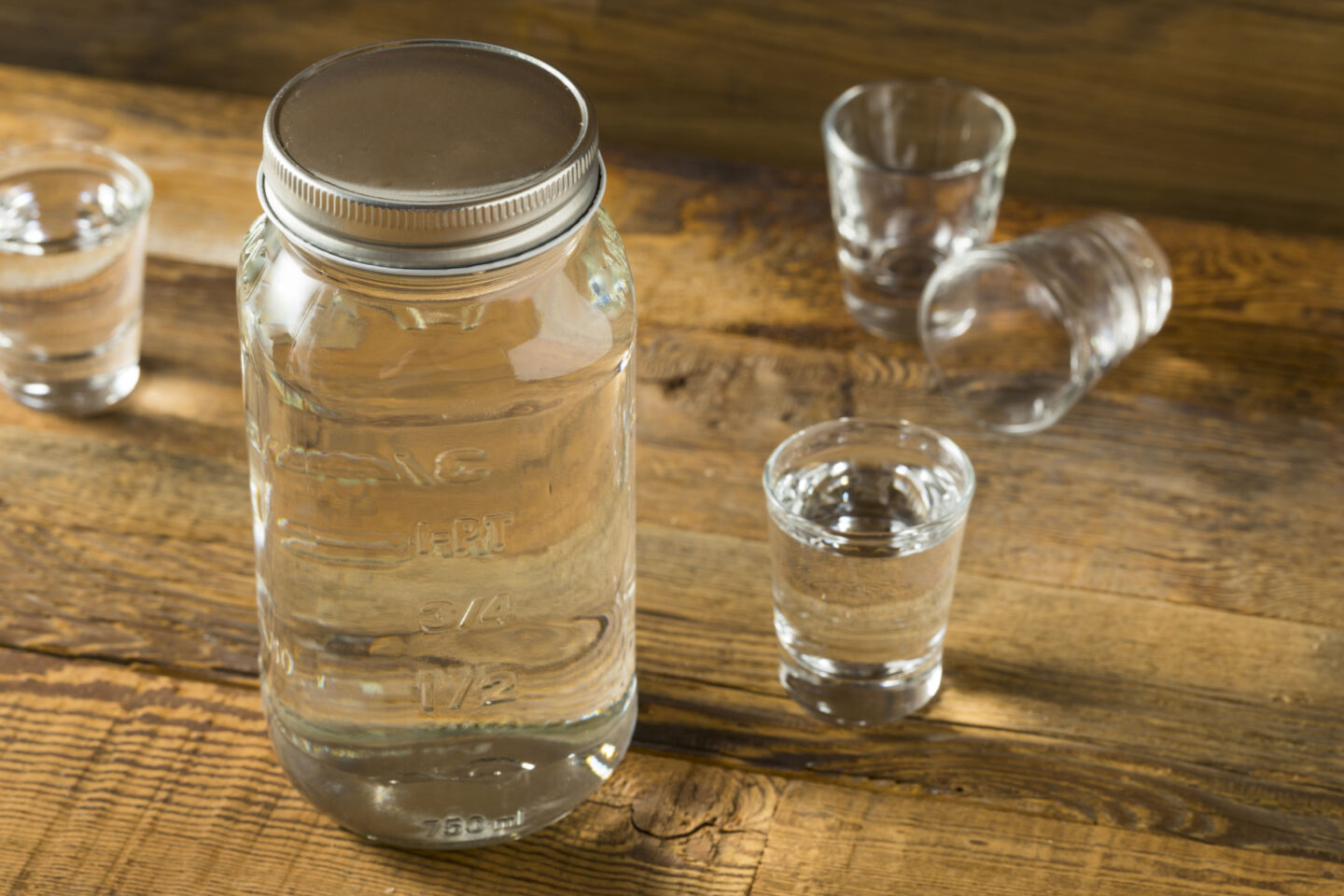 american moonshine in mason jar and shot glasses