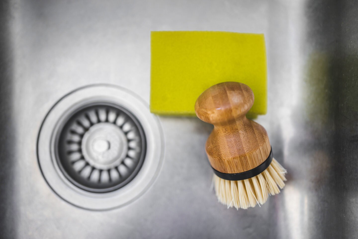 cleaning the sink with brush and sponge