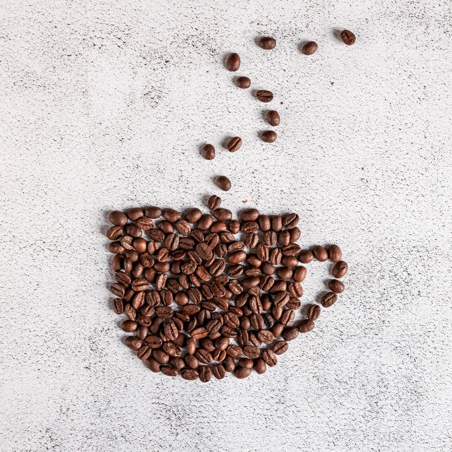 coffee beans shaped into a steaming cup of coffee on white background