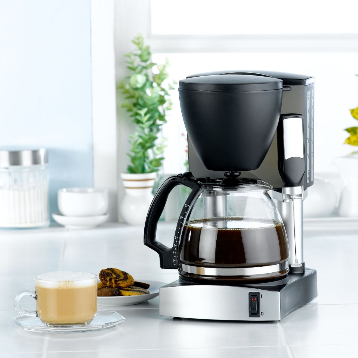 coffee in drip coffee machine and in glass mug on reflective surface