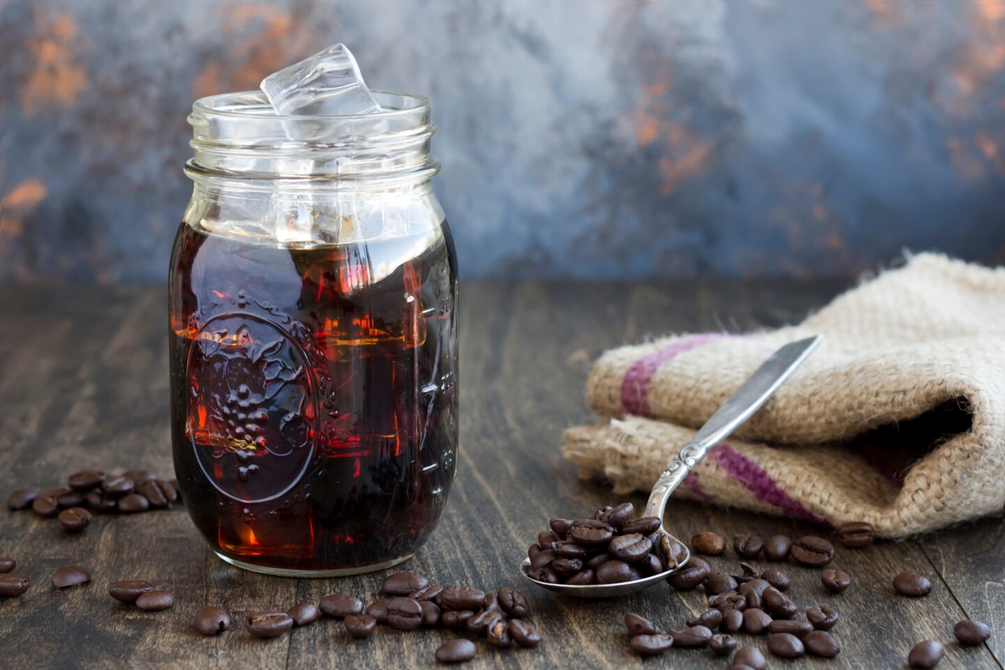 Iced,Coffee,In,A,Glass,Jar,With,A,Spoon,Full