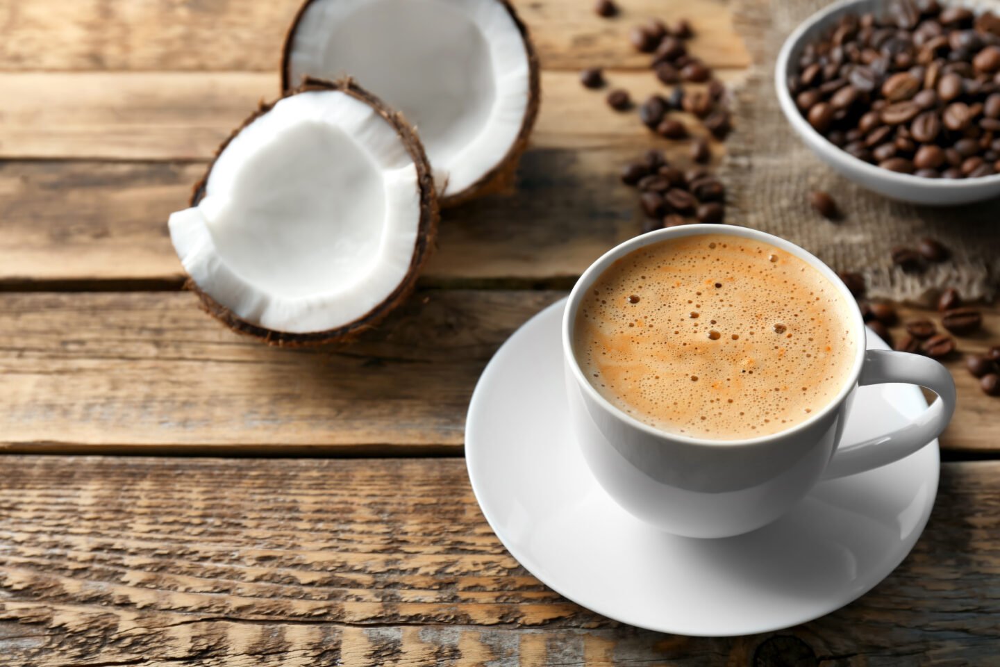 Cup,Of,Tasty,Coconut,Coffee,And,Beans,On,Wooden,Table