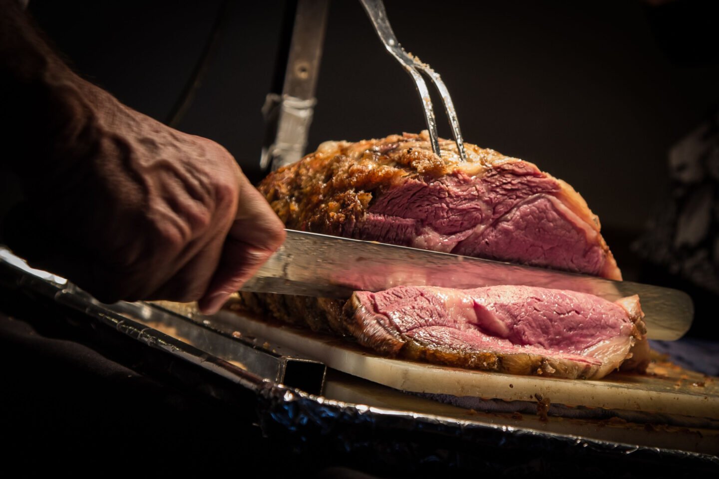 cutting up prime rib with crunchy crust