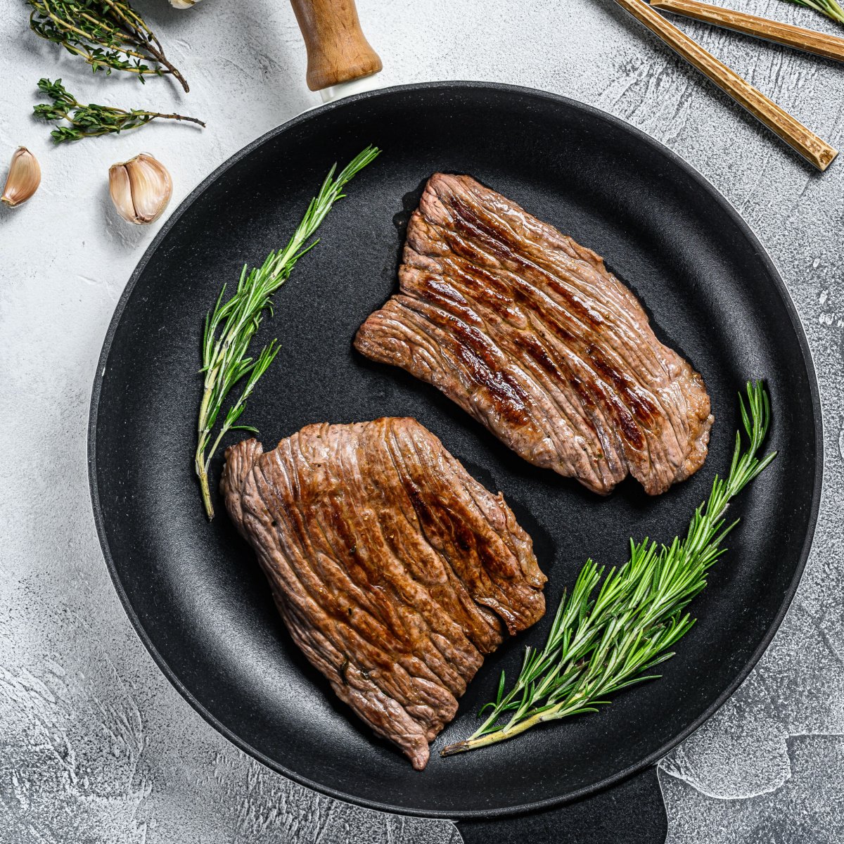 grilled flat iron and flank steaks in a pan