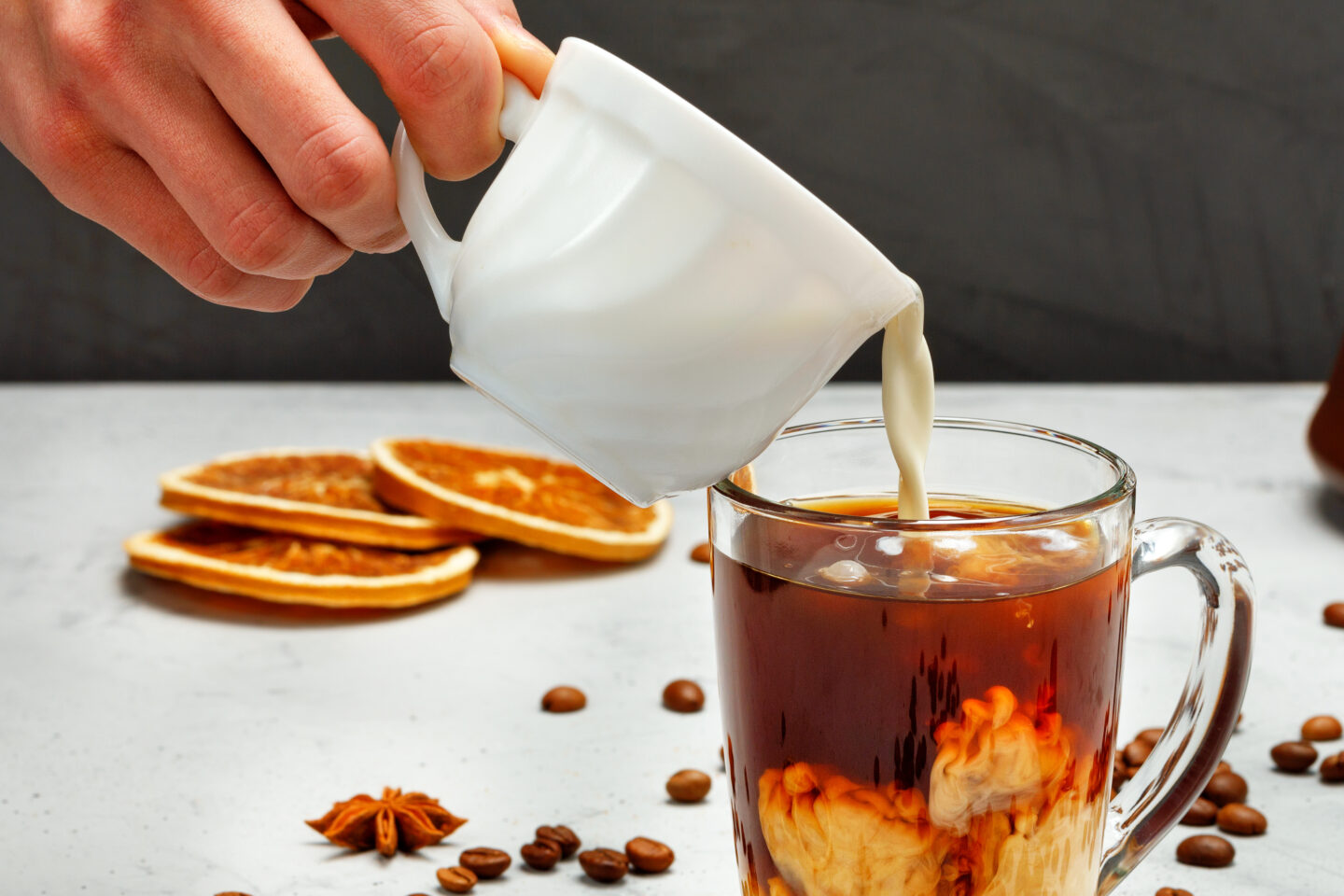 A,Human,Hand,Pours,Heavy,Cream,From,A,White,Cup