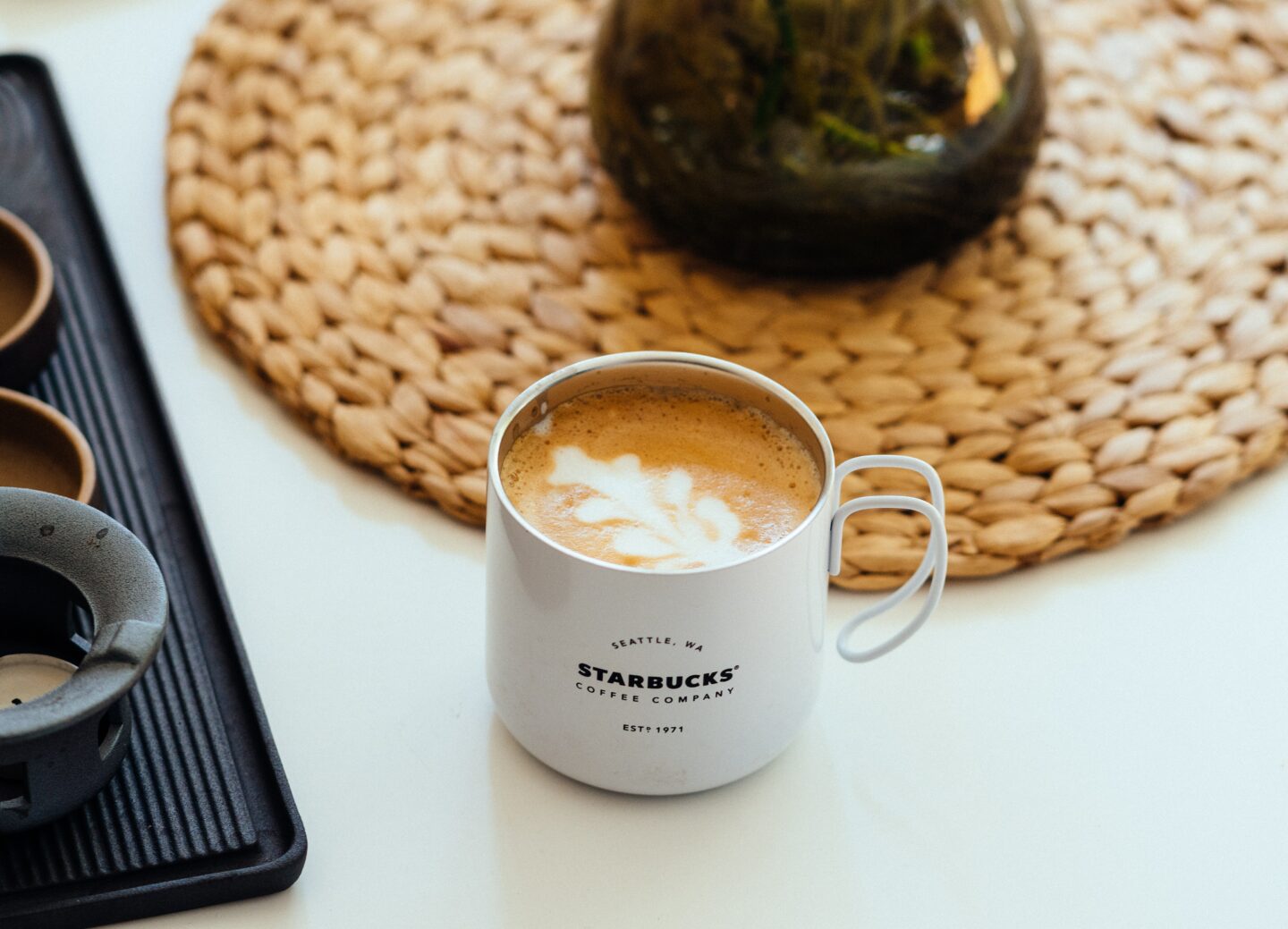 hot cappuccino in white starbucks ceramic mug on white table