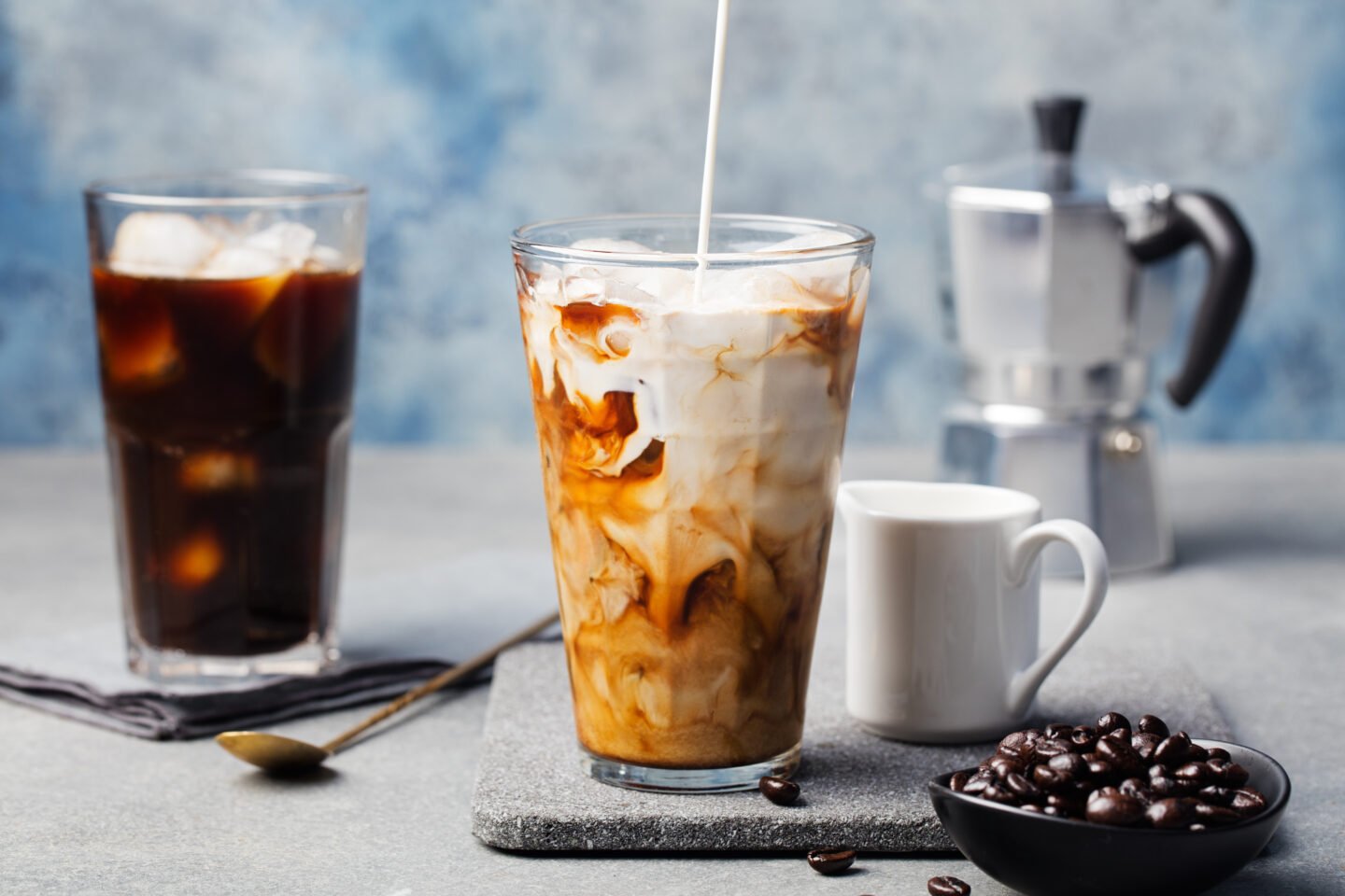 Ice,Coffee,In,A,Tall,Glass,With,Cream,Poured,Over