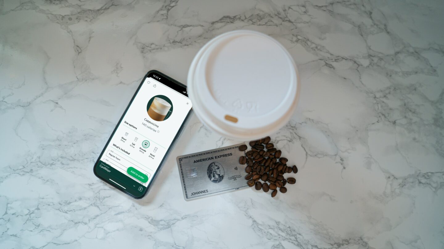 ordering drink on starbucks app in phone beside american express card