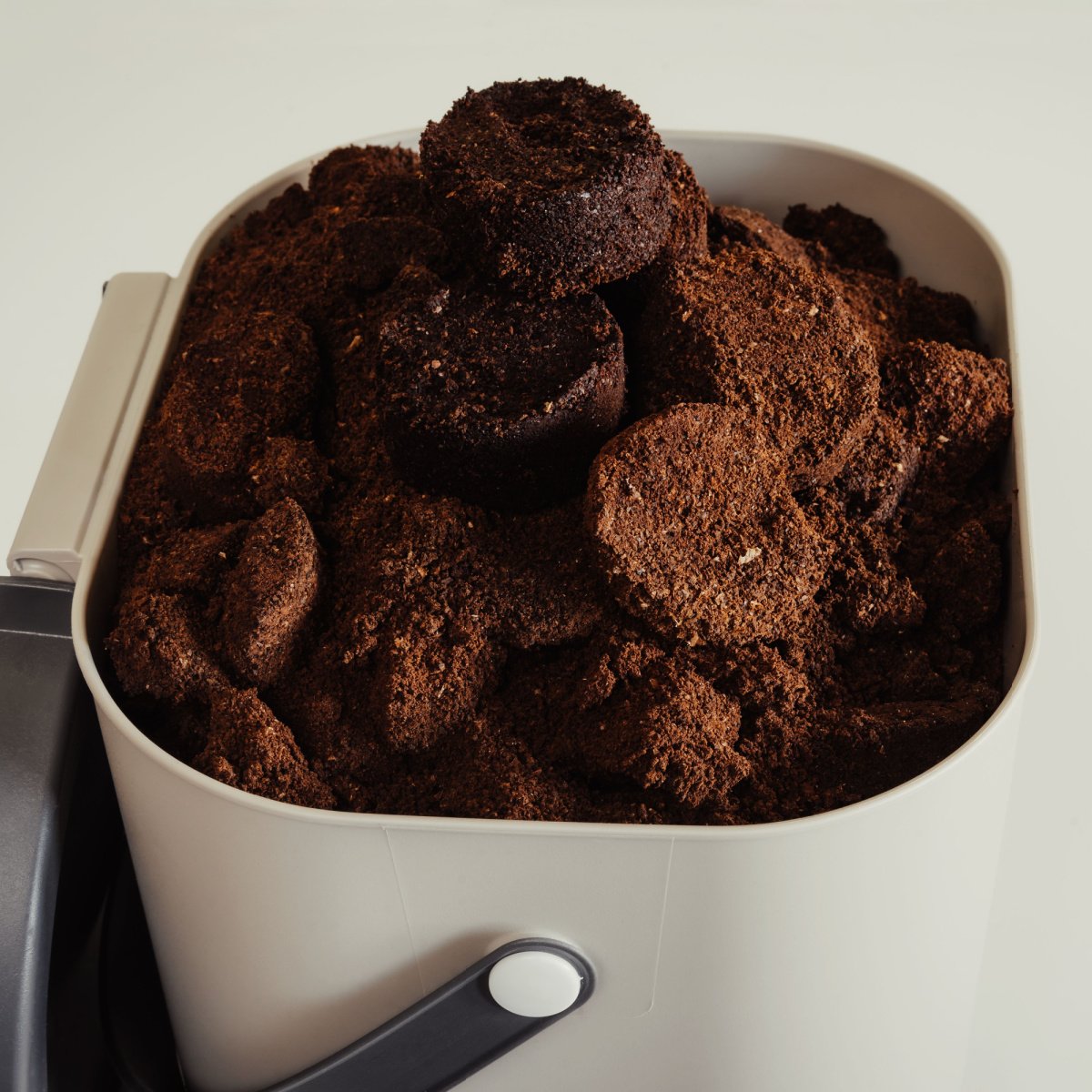 piles of used coffee grounds in container ready for disposal