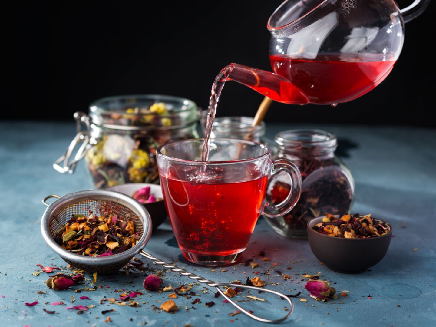 pouring fruit and herbal tea into glass cup
