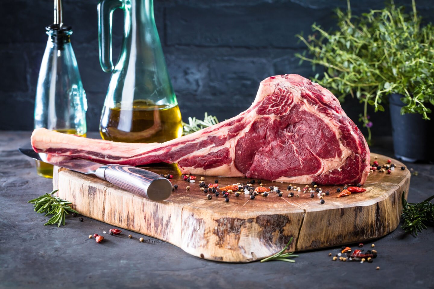 raw tomahawk steak on a kitchen board