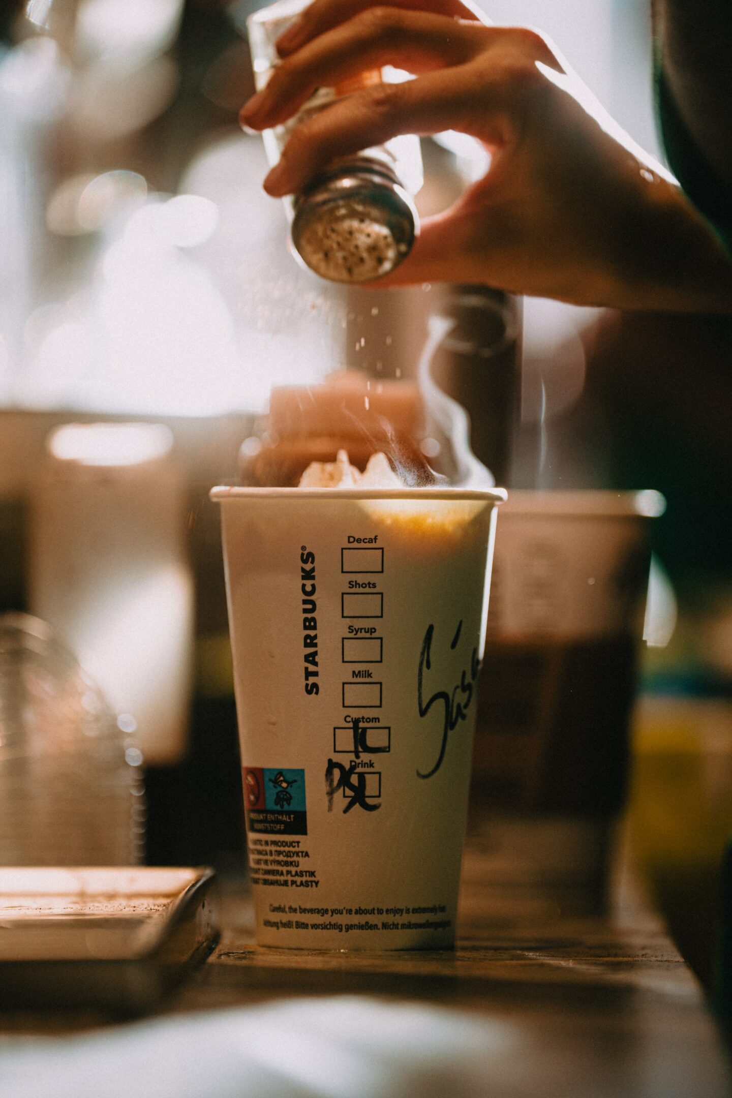 starbucks barista adding spice to drink they are making