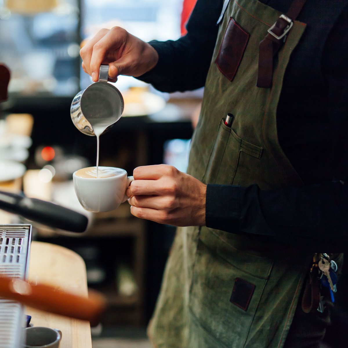 starbucks barista making hot latte in white ceramic mug handcrafted drink