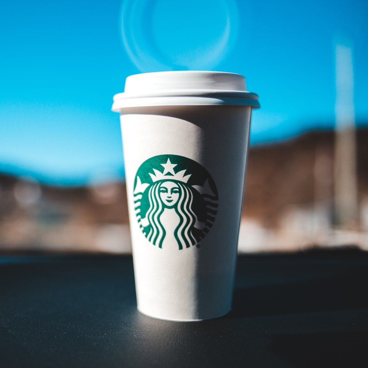starbucks disposable cup on windowsill showing reflection