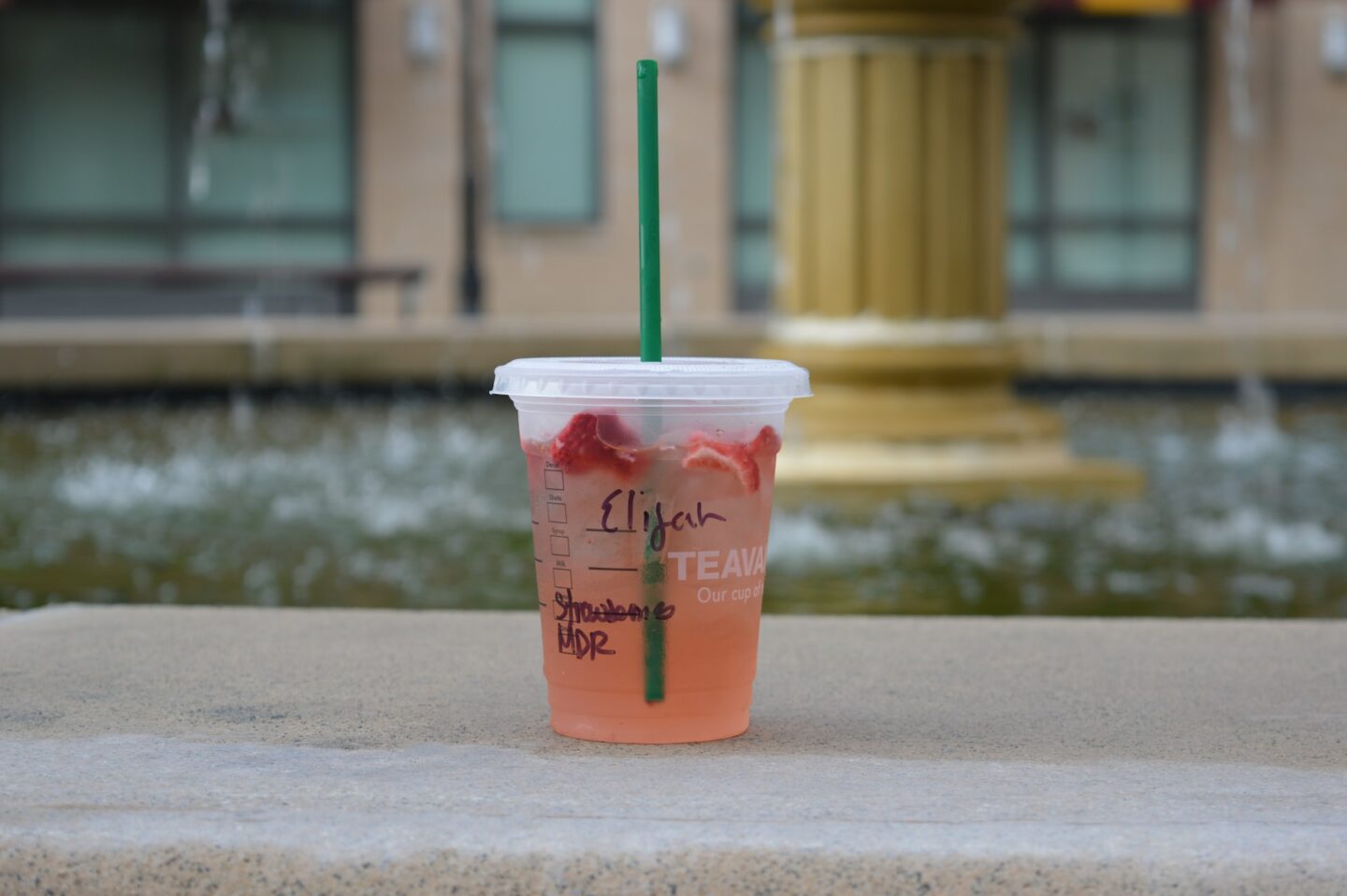 starbucks strawberry refresher in disposable cup on concrete surface