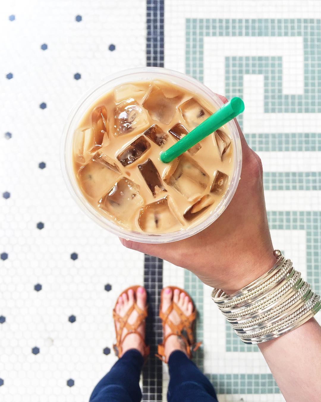top down view of hand holding starbucks iced coffee with straw