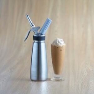 whipped cream in whipped cream dispenser beside glass of coffee topped with whipped cream on wooden table