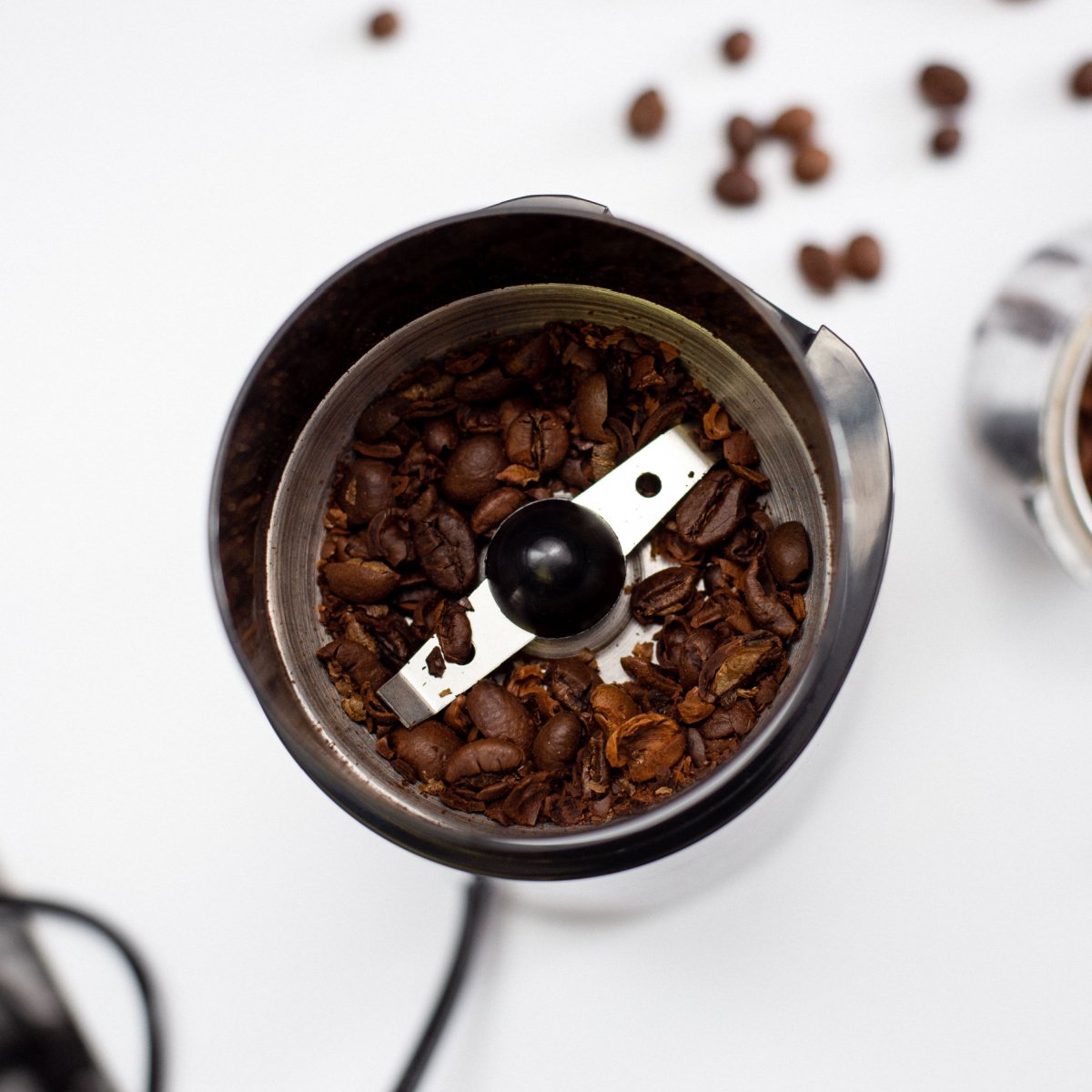 whole fresh coffee beans in grinder with milling blade