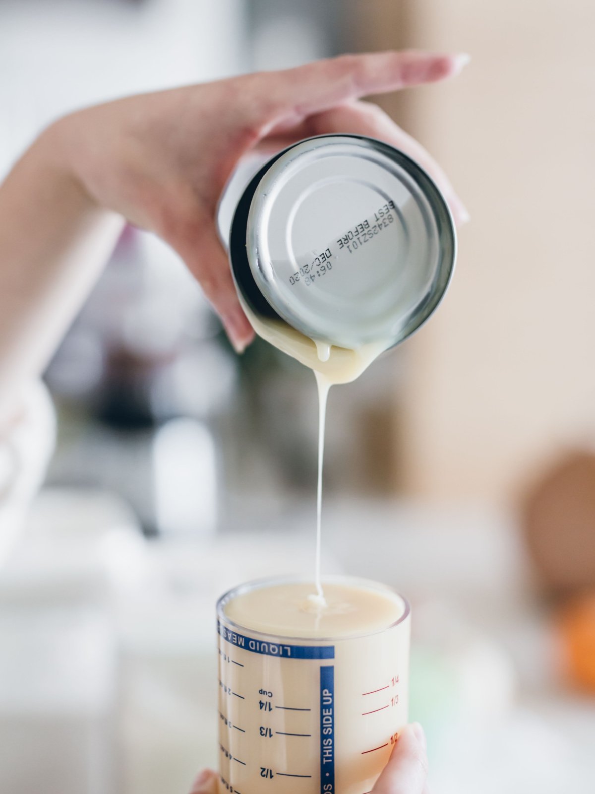 woman pouring heavy cream into measuring cup