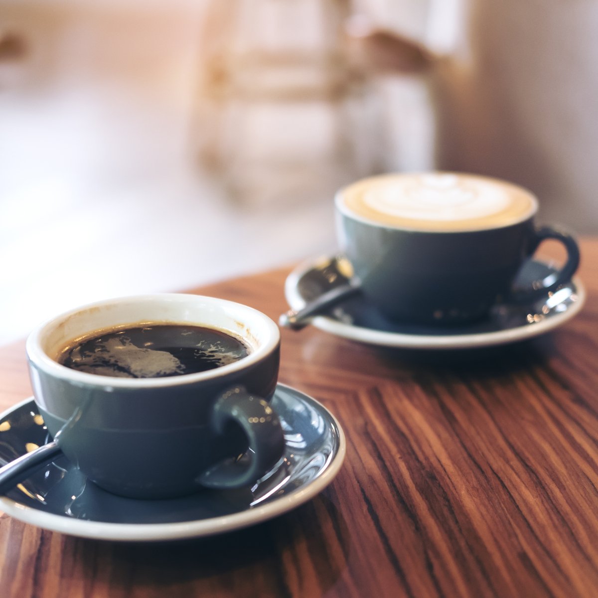 a-cup-of-americano-and-cappuccino-on-a-wooden-table