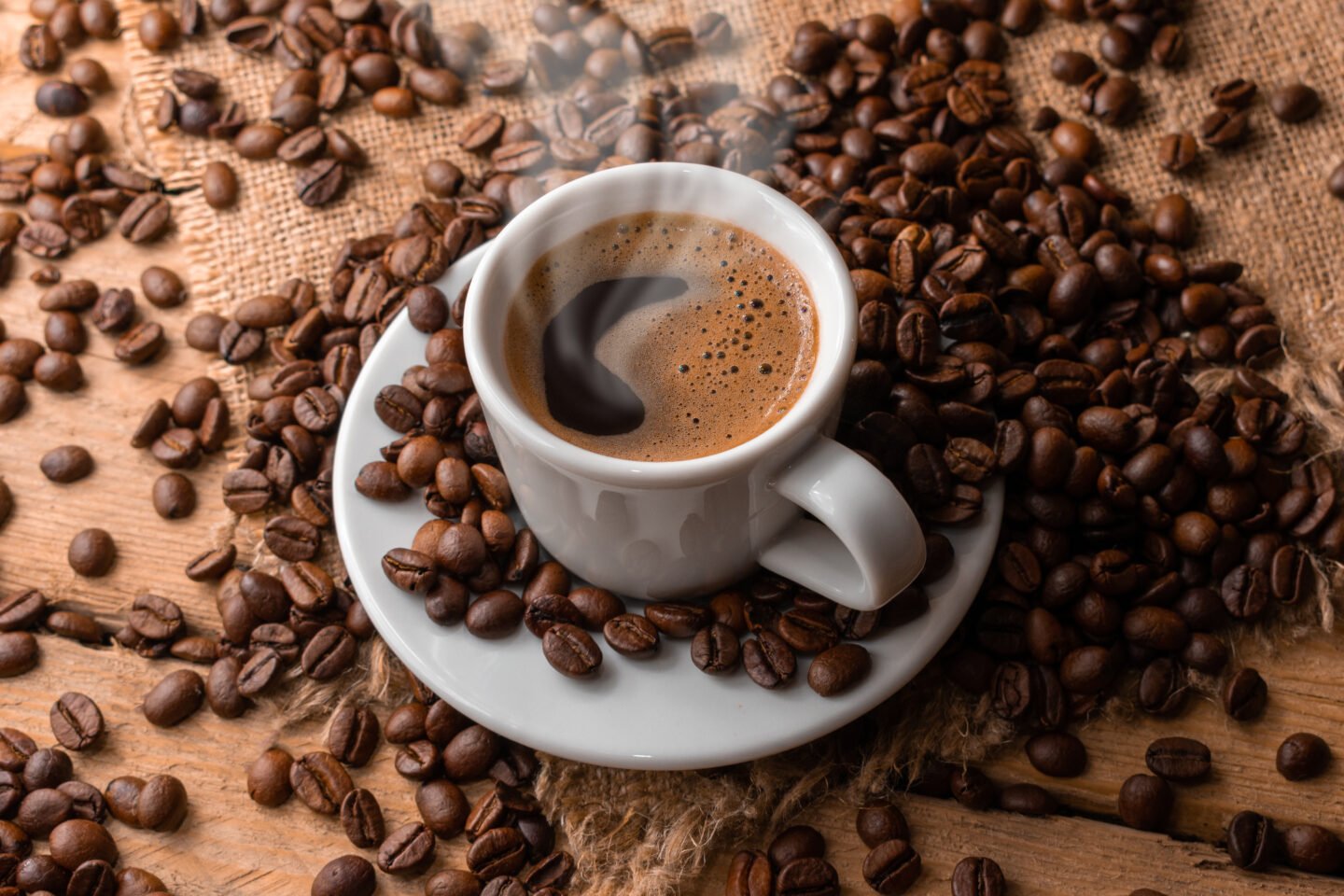 a-cup-of-hot-coffee-surrounded-by-scattered-coffee-beans