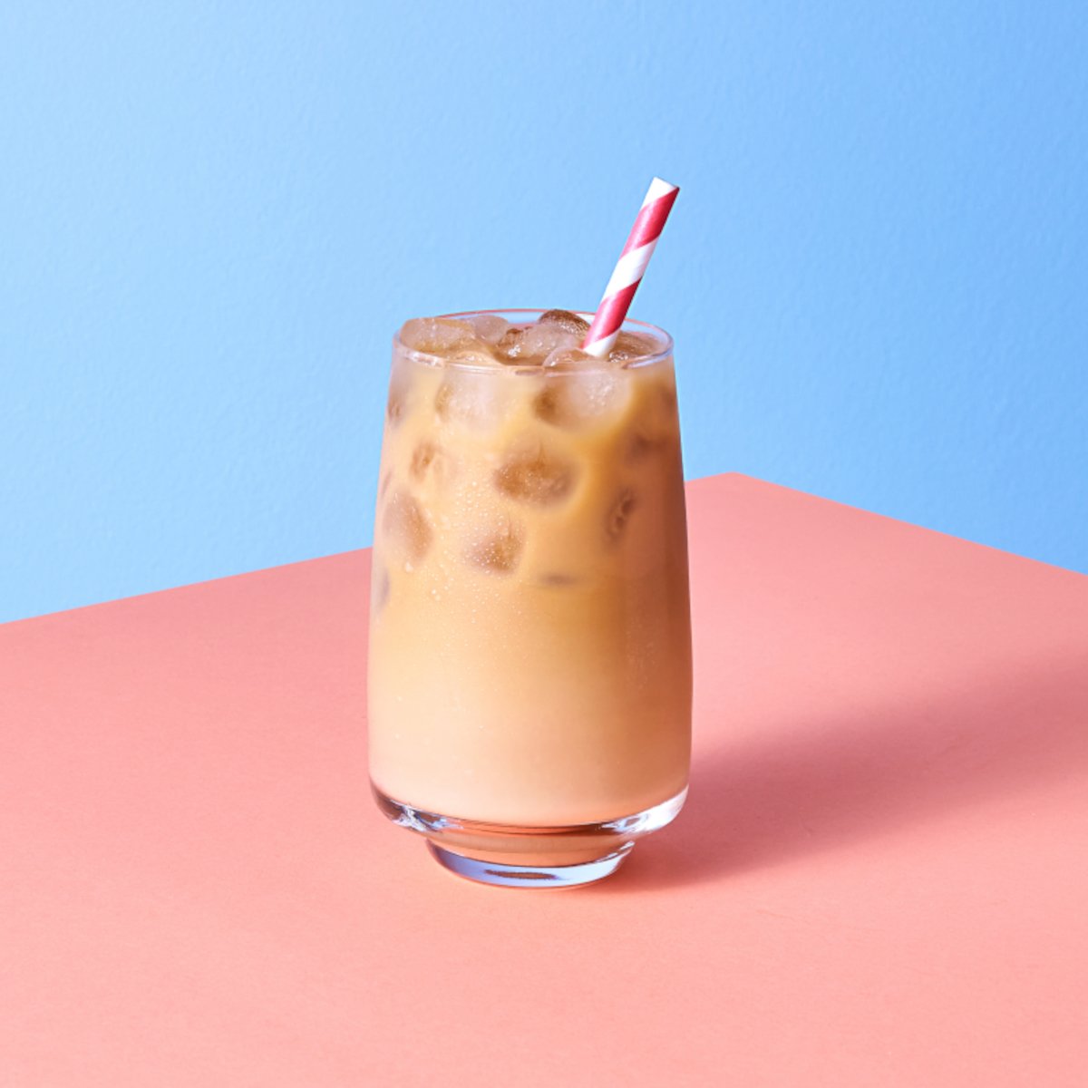 a-glass-of-iced-coffee-with-a-cute-straw-on-a-pink-and-blue-background