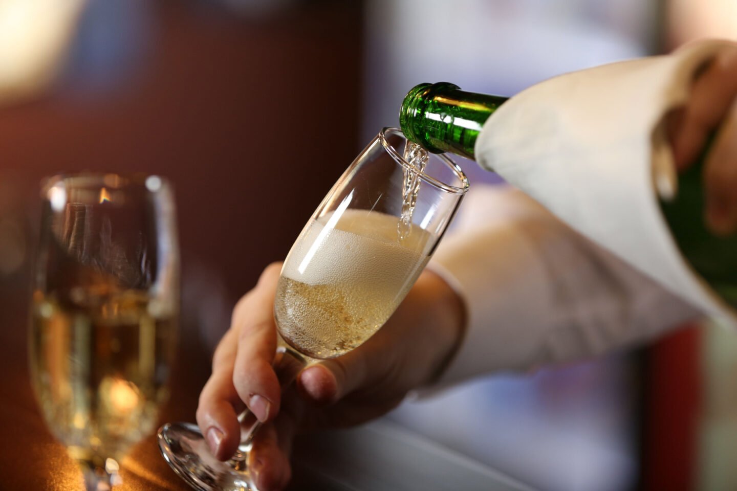 bartender pouring champagne into glass