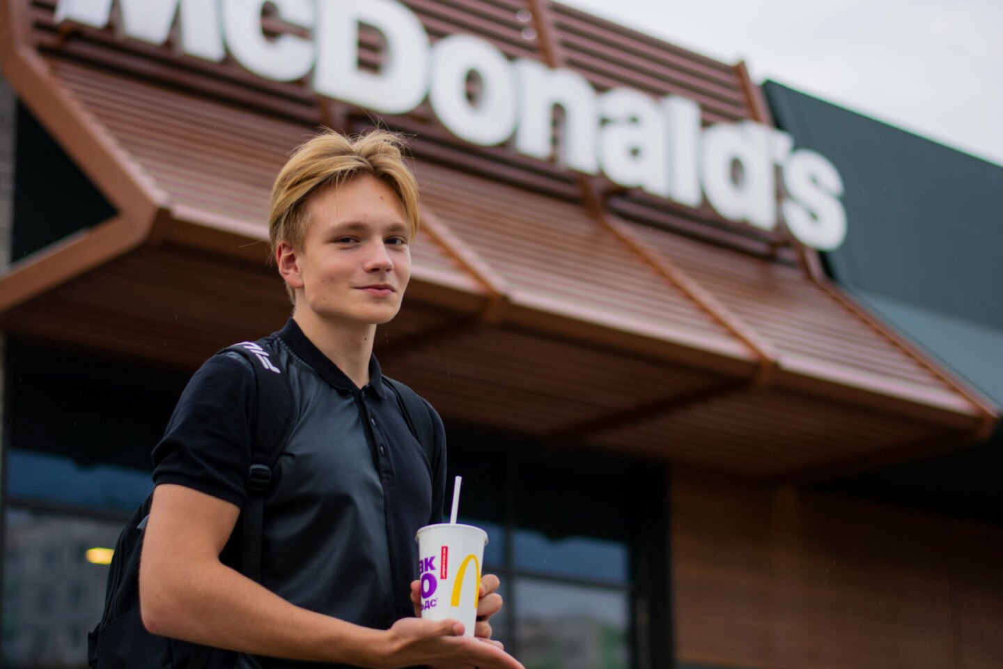 blond person standing in front of mcdonalds