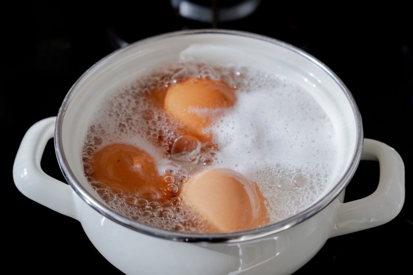 boiling brown eggs in white pot