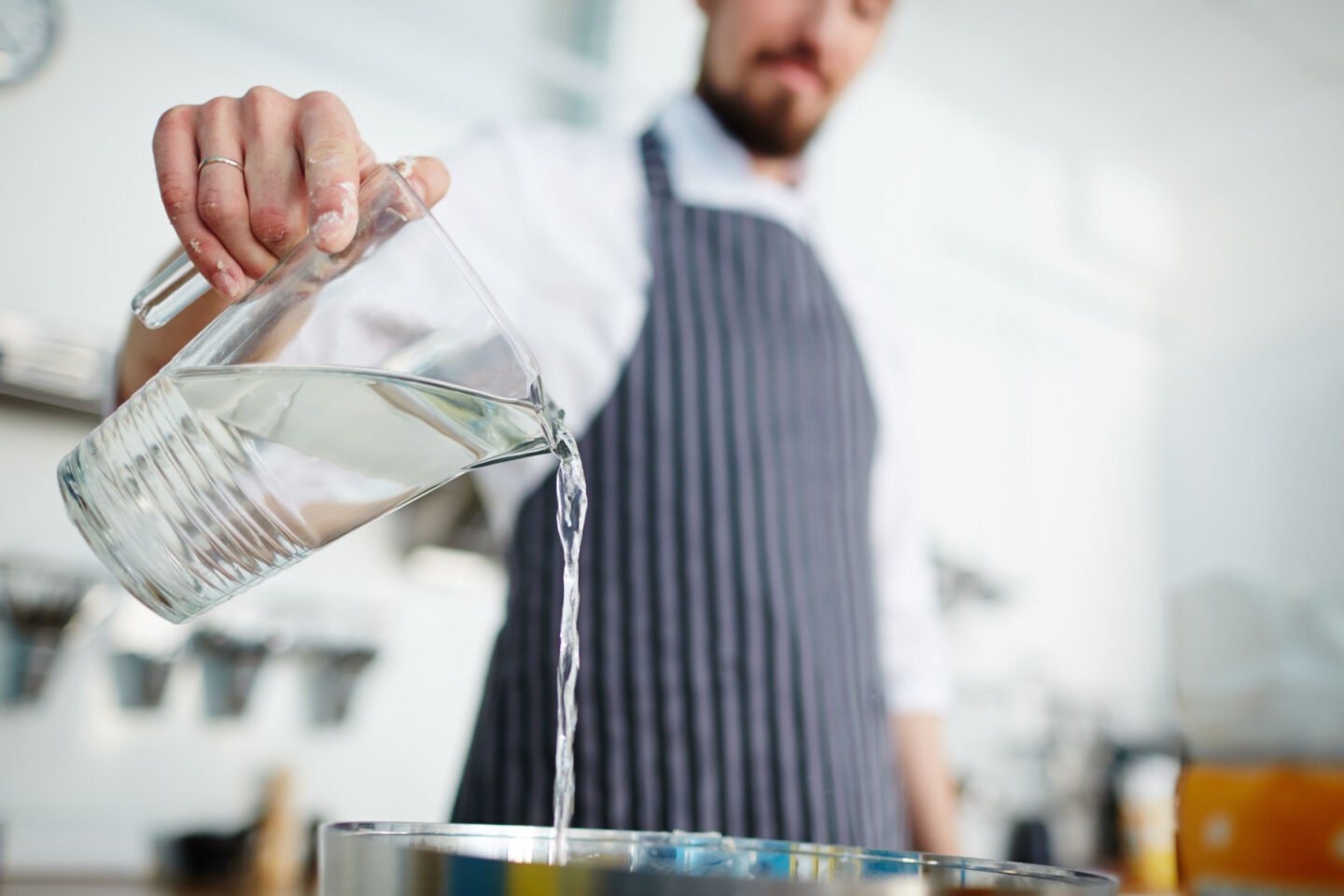 chef pours water into pot