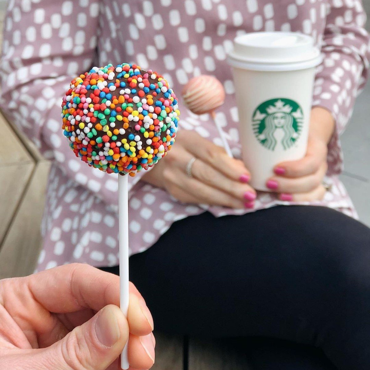 close up on hand holding starbucks vanilla fudge cake pop