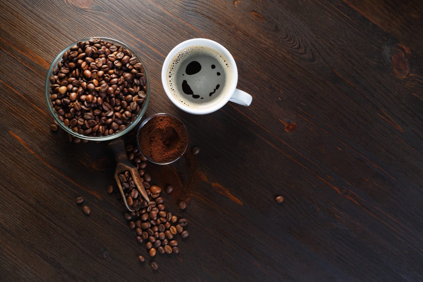 coffee-cup-coffee-beans-and-ground-powder-on-wooden-background