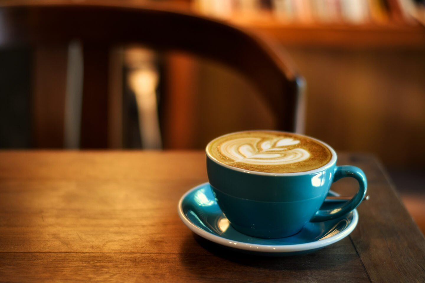 coffee-in-blue-cup-on-wooden-table-in-cafe