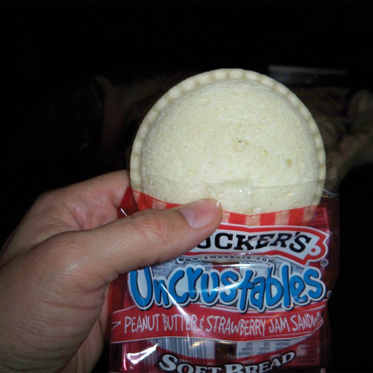 eating smuckers uncrustables sandwich