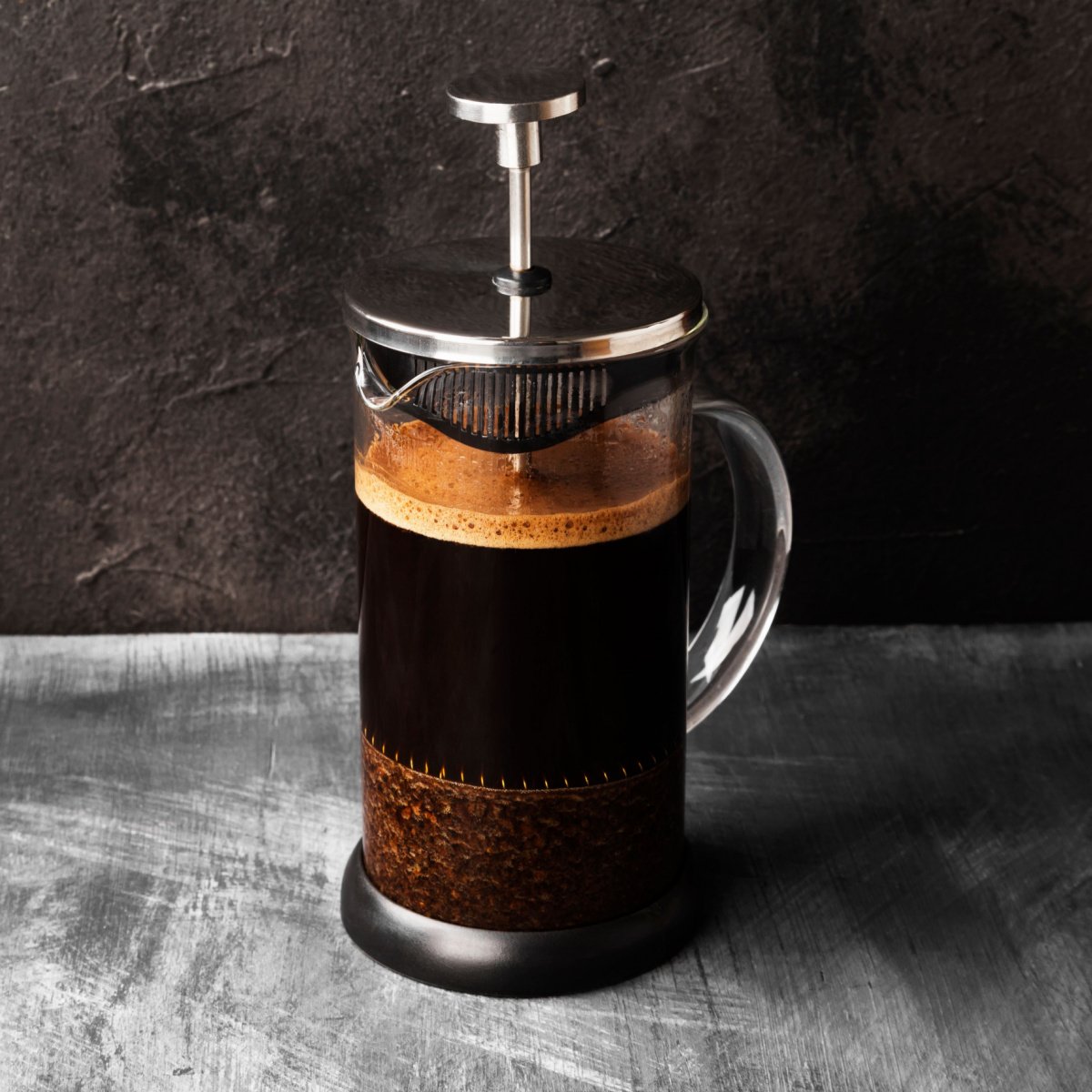 freshly made coffee in french press on wooden surface