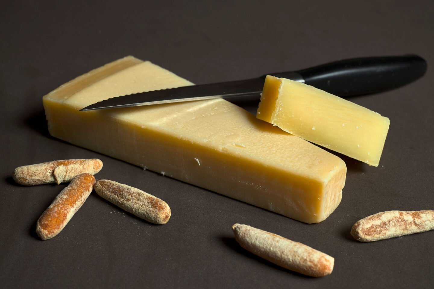 Grana Padano Italian cheese with bread sticks and cheese knife