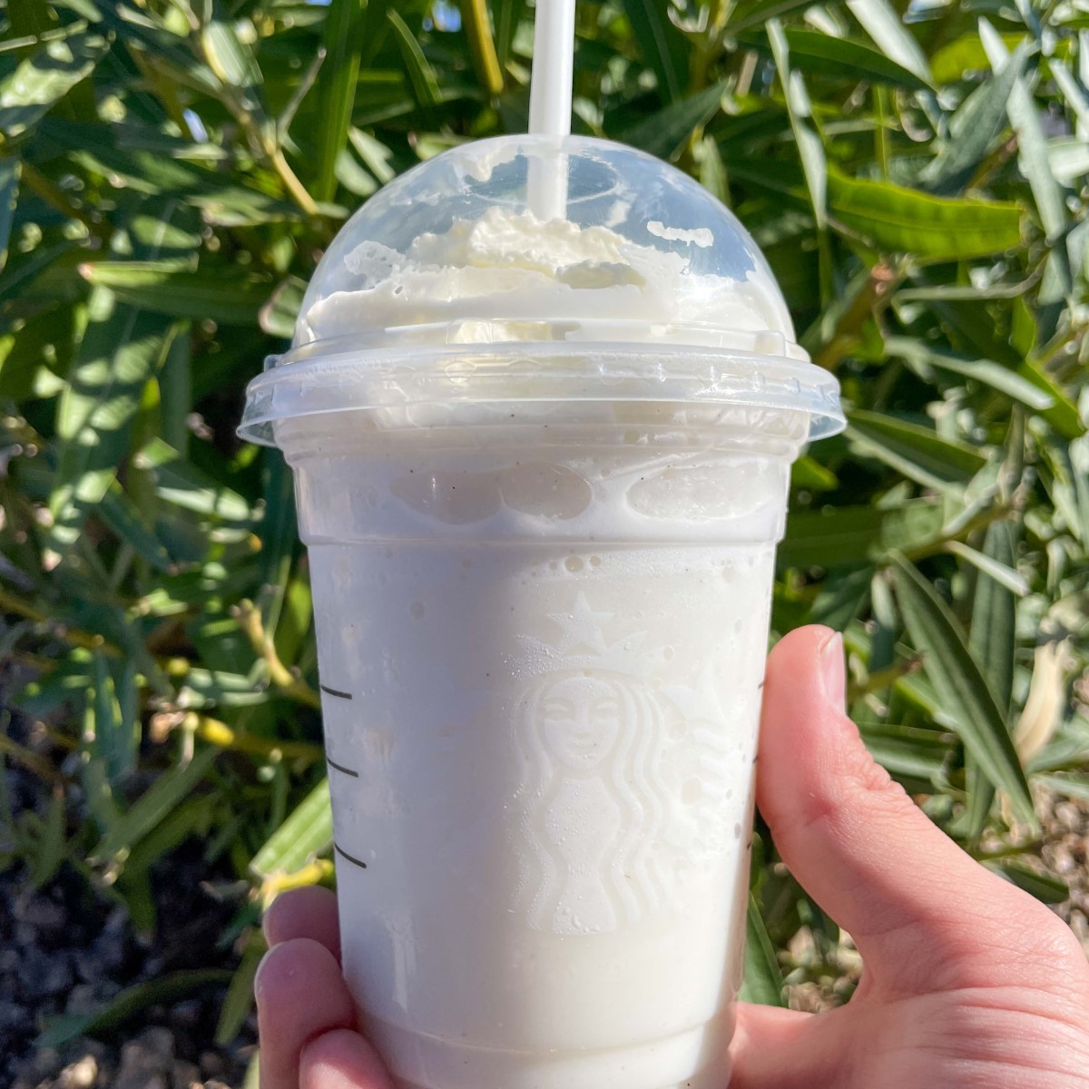 hand holding up cup of starbucks cotton candy frappuccino