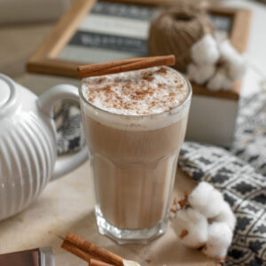 homemade chai latte in tall glass on wooden table