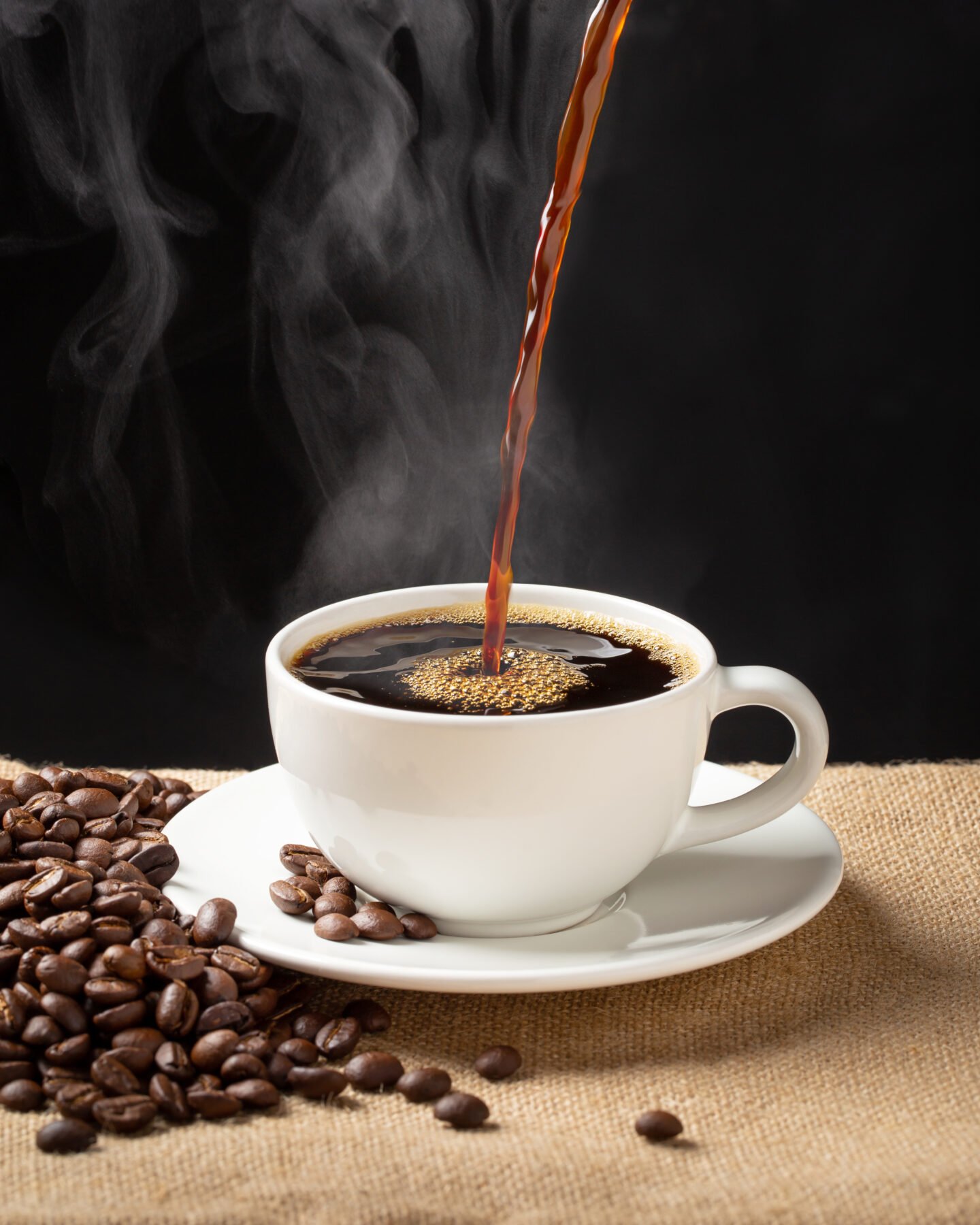 hot-coffee-in-a-white-cup-beside-coffee-beans